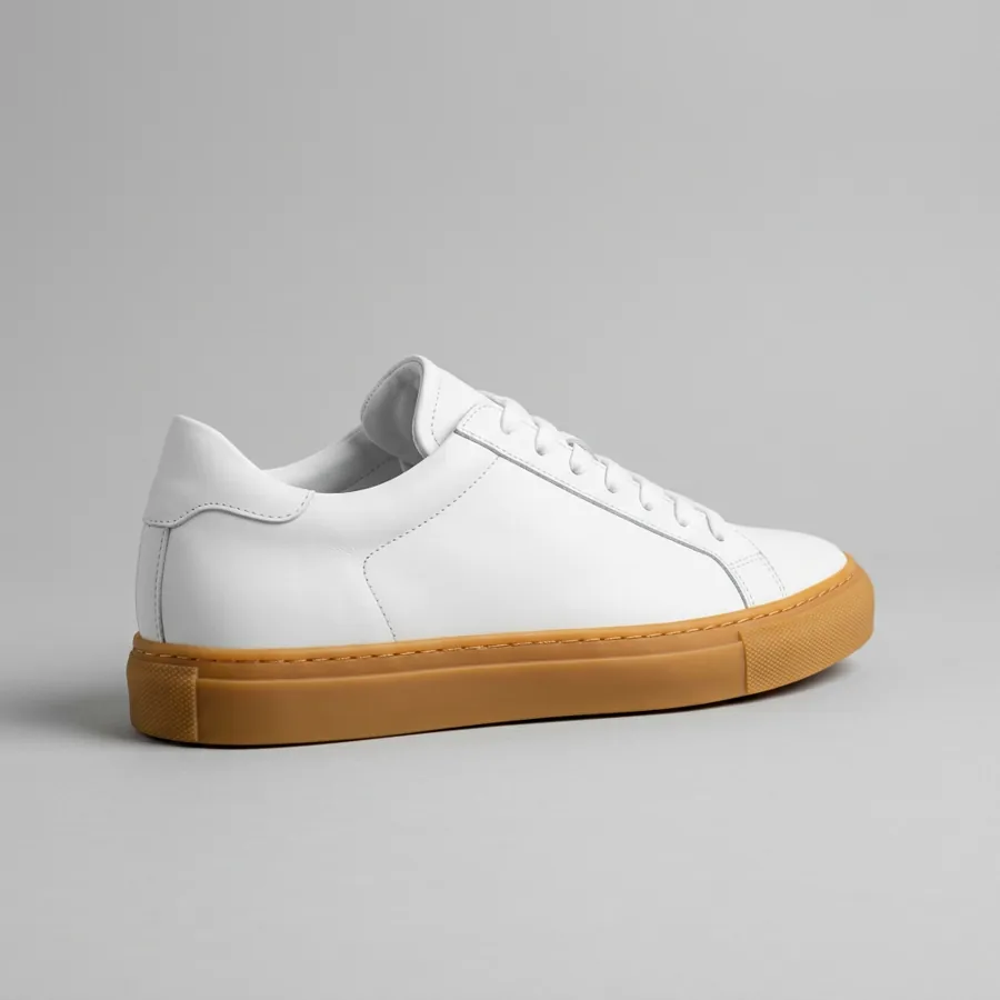 The sneaker photo that went in: a white leather sneaker with a gum sole on gray