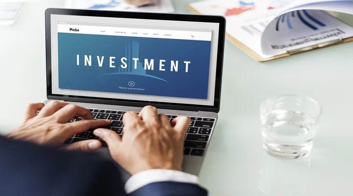 Illustration of a person typing on a laptop with the screen displaying "Investment", symbolizing social media post ideas on stock market investment
