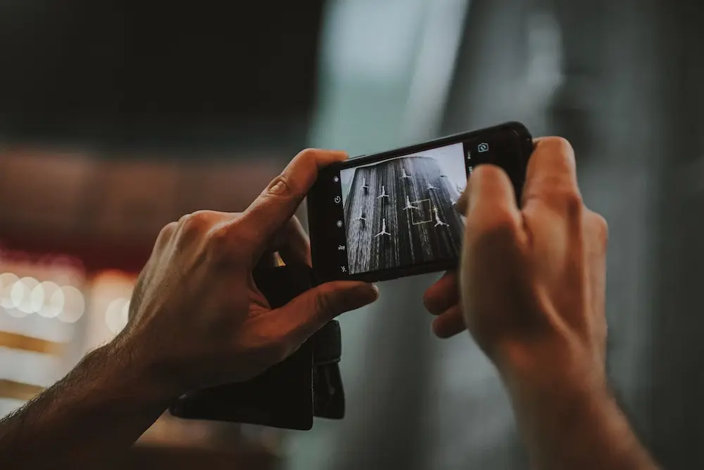 A person taking a picture of a street with a cell phone