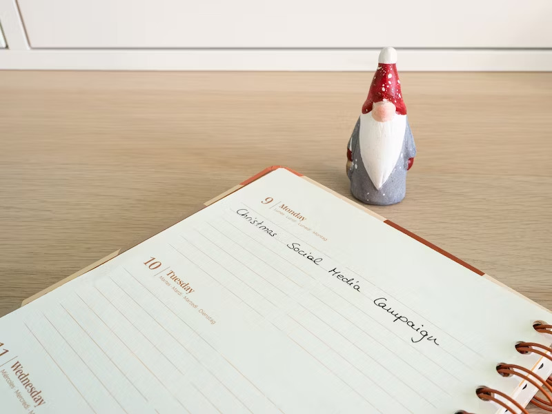 A notepad with a pen and a gnomes hat on top of it